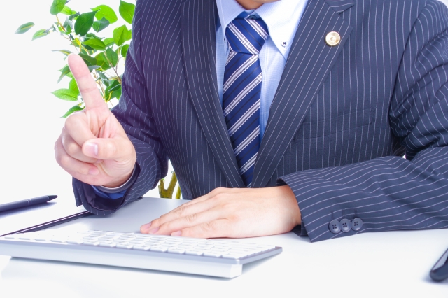 スーツを着た男性が人差し指を立てている