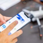 スマホと操作する手とドローン